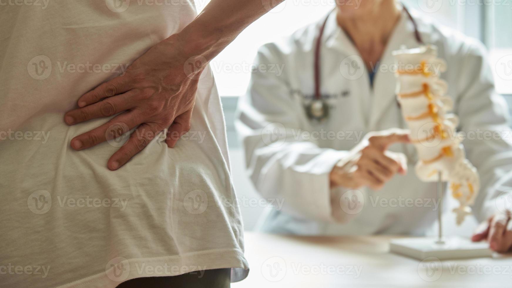 paziente con mal di schiena in visita dal medico in clinica foto