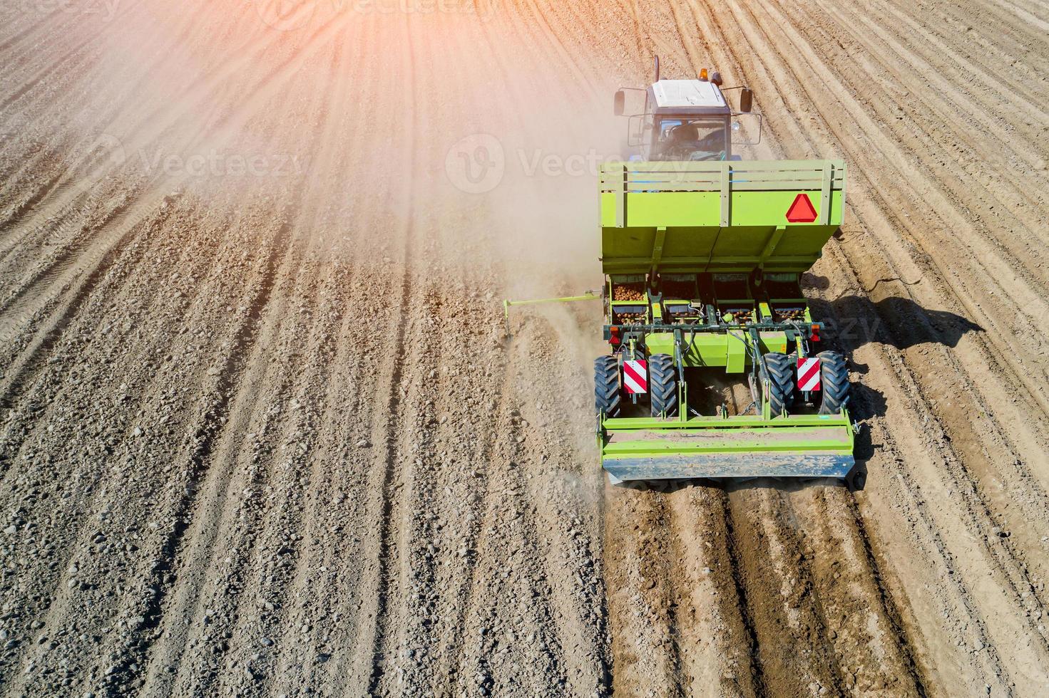 un contadino e un trattore nel campo piantando patate nei fertili campi agricoli. vista aerea. foto