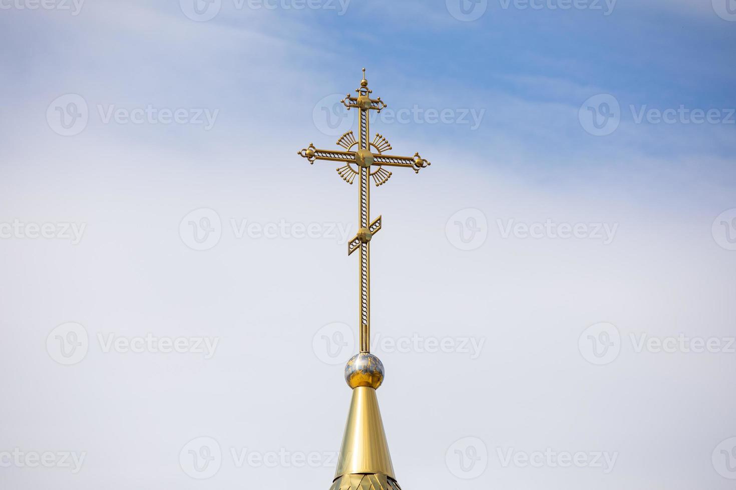 la cupola dorata e la croce della chiesa ortodossa contro il cielo azzurro e le nuvole. foto