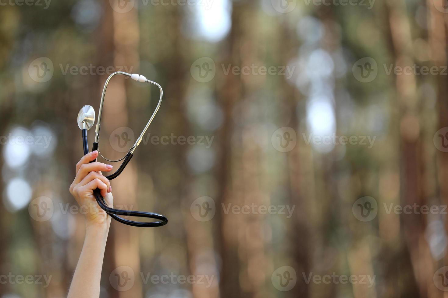 stetoscopio per mano, isolato su sfondo naturale. concetto ama l'ambiente. messa a fuoco selettiva. copia spazio. cure mediche foto