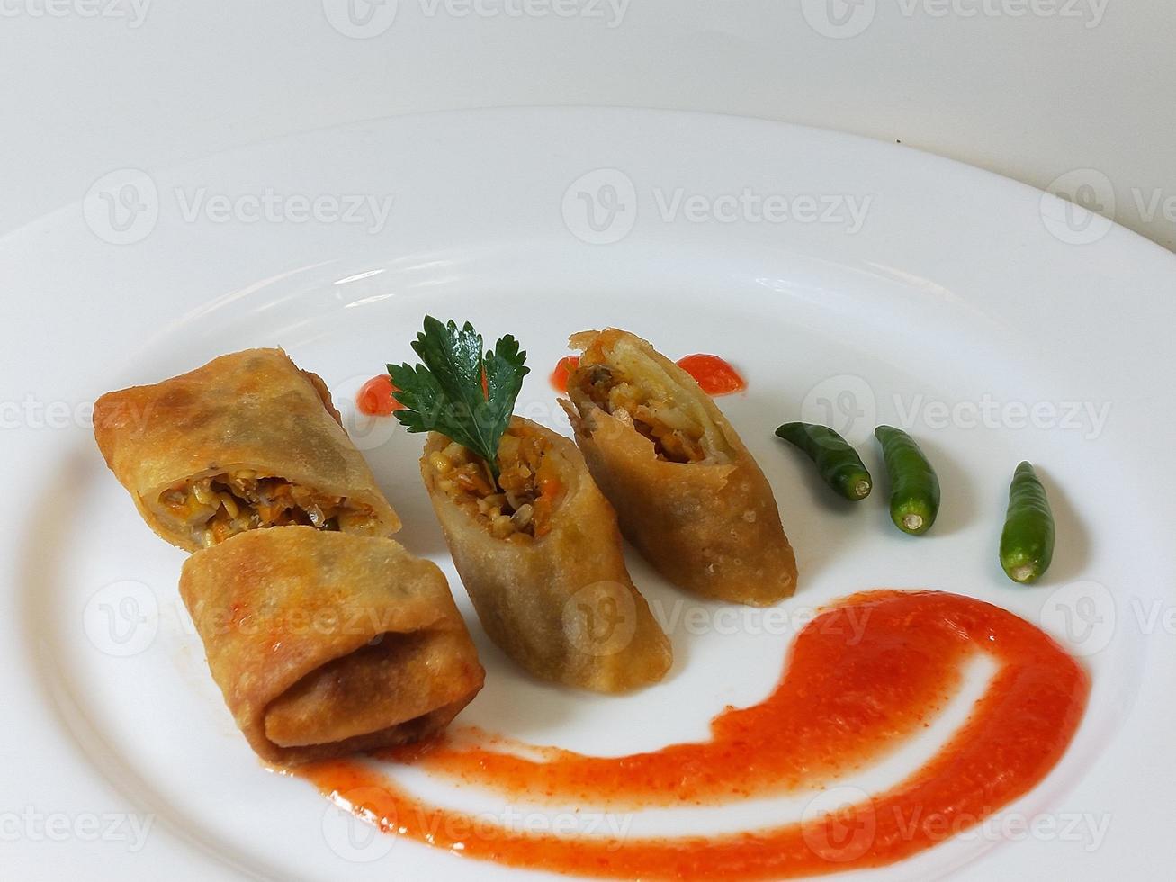 lumpia è un tipico spuntino indonesiano giavanese centrale costituito da una miscela di giovani germogli di bambù, uova, verdure fresche e carne o frutti di mare, in un rotolo di fogli sottili di farina di frumento foto