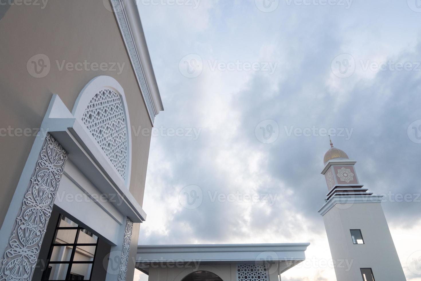 vista della costruzione della moschea con il minareto e lo sfondo del cielo blu. dettagli architettonici, interni e della torre foto