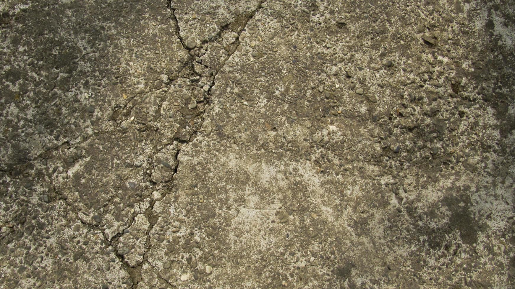 vecchio cemento fessurato. muro di cemento in cemento grunge con crack, per il tuo design e texture di sfondo. passerella in pietra. struttura in cemento foto