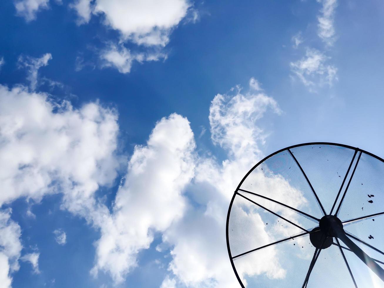 un'immagine di un cielo nuvoloso diurno e una parabola satellitare della TV di casa. foto