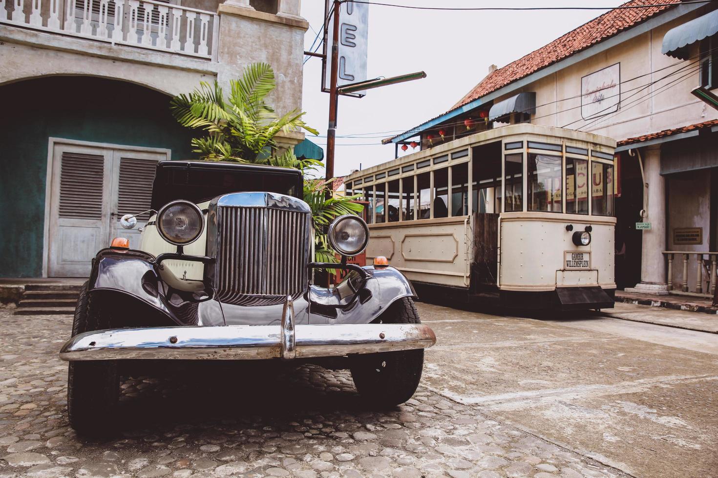 auto d'epoca parcheggiata davanti al vecchio hotel con vagabondo che passa per strada. yogyakarta, indonesia-marzo 2022 foto