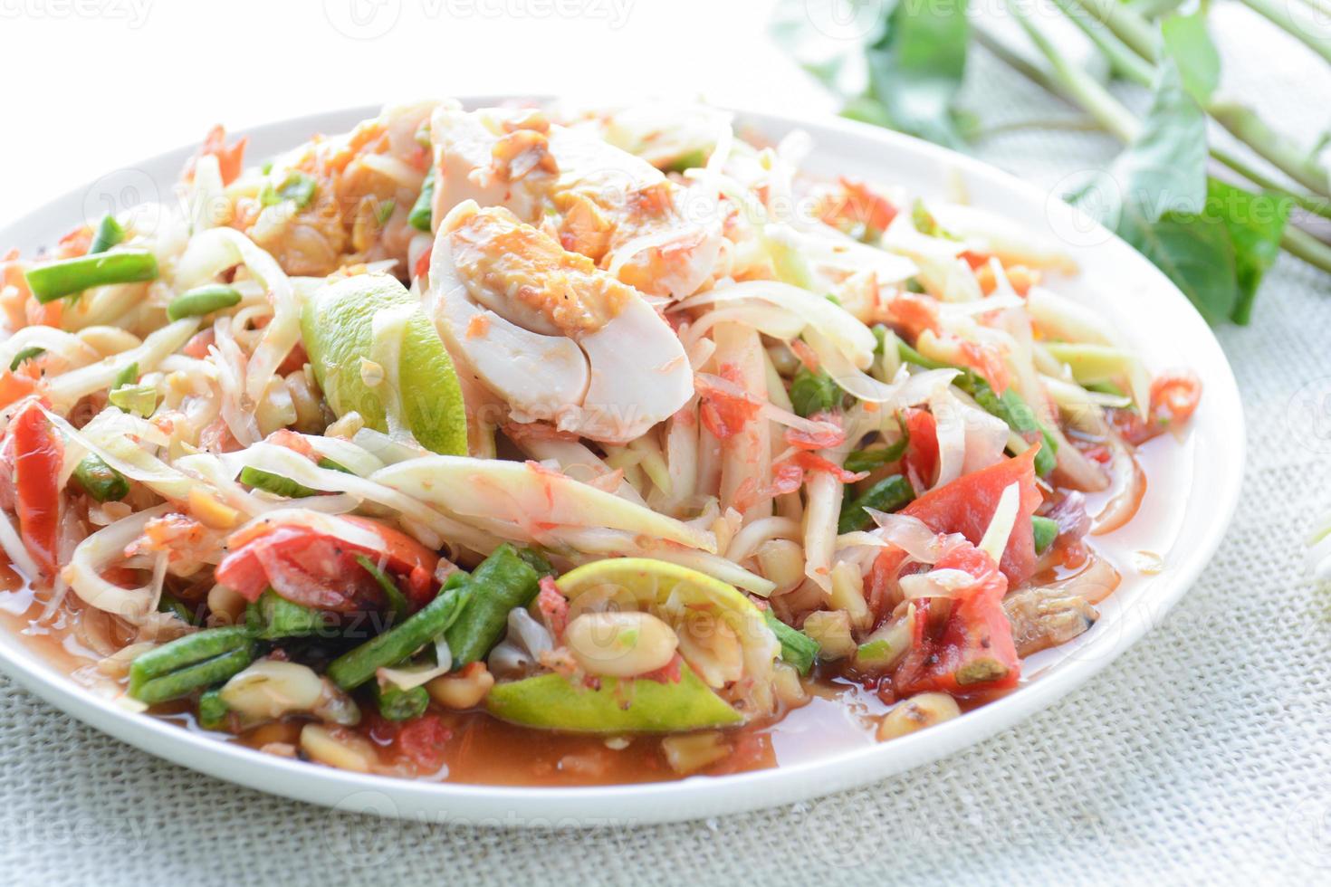 insalata di papaya con uova sode, pestare i peperoncini e l'aglio, quindi mettere il pomodoro a fette, le melanzane e l'uovo salato. aggiungere la salsa di pesce, il limone, lo zucchero, la papaya tritata poi amalgamare tutti gli ingredienti. foto