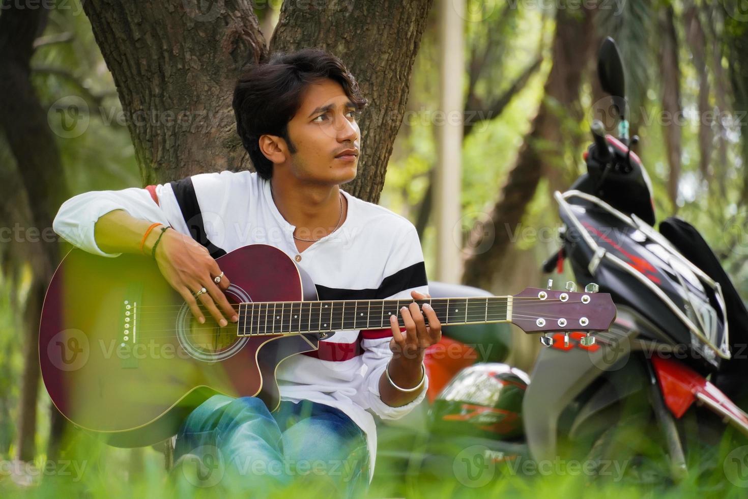 ragazzo con chitarra rossa con bici rossa foto