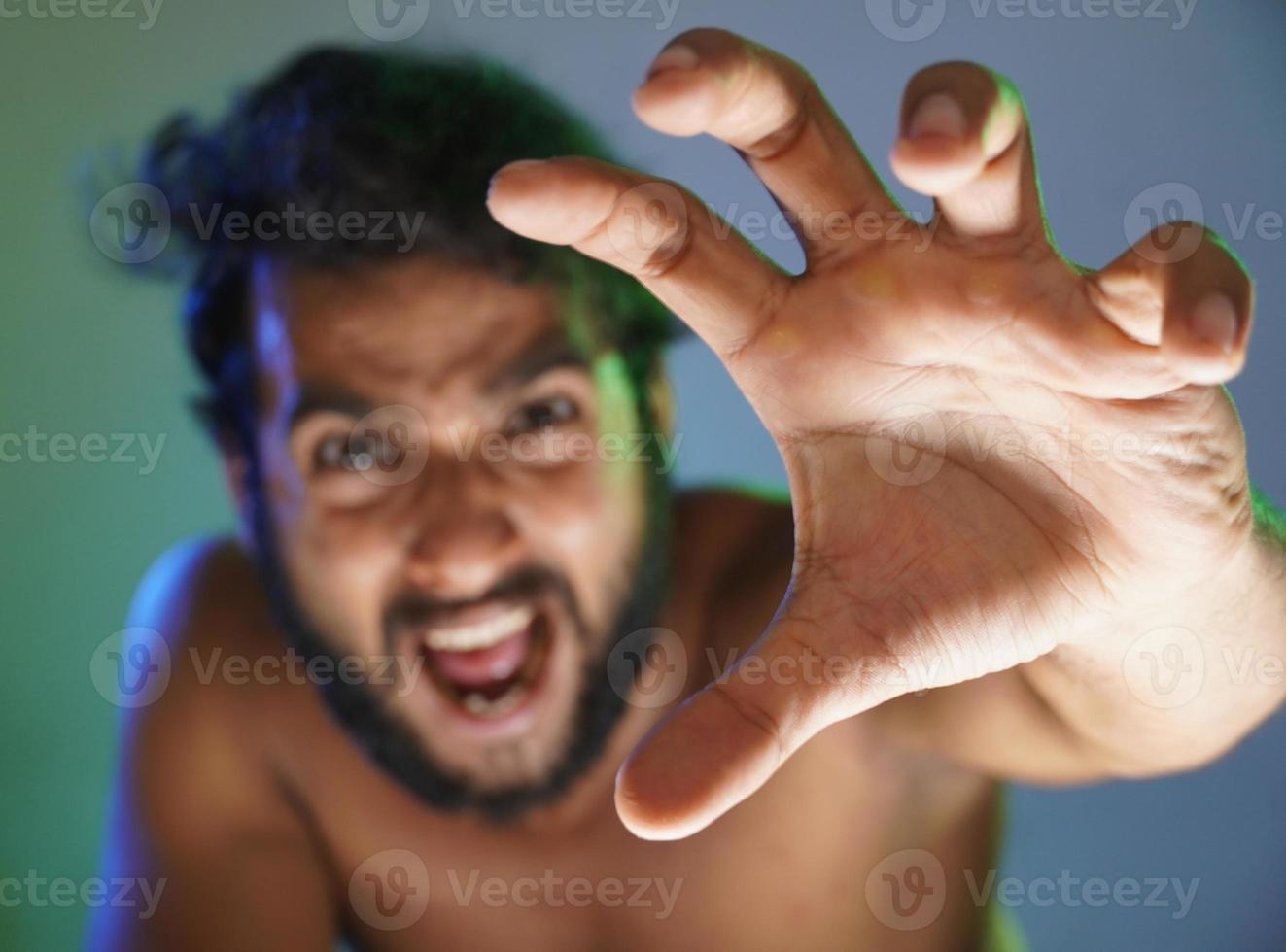 giovane faccia arrabbiata che indica la mano a voi immagine di messa a fuoco selettiva girato in studio foto