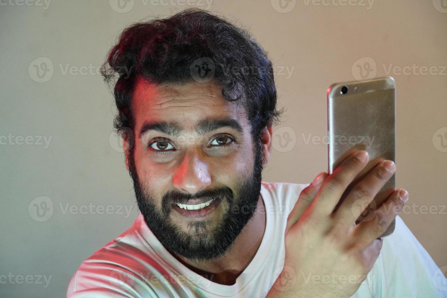 un uomo che usa il cellulare e felice foto