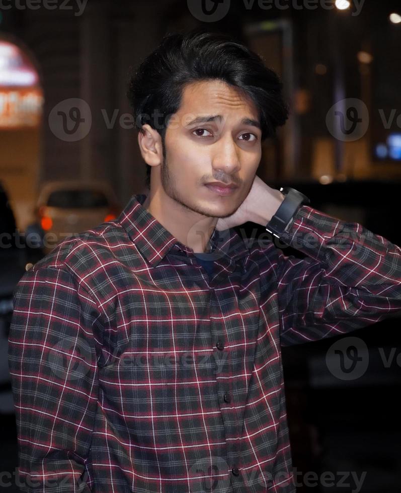 il giovane uomo bello indiano indossa la camicia e dà posa foto