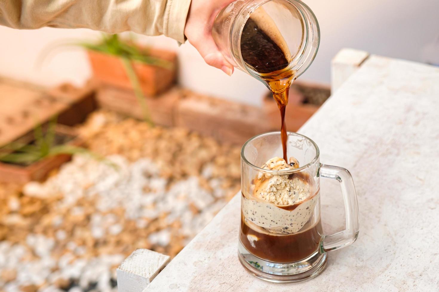 caffè affogato con gelato su una tazza di vetro con sfondo giardino, cocktail estivo foto