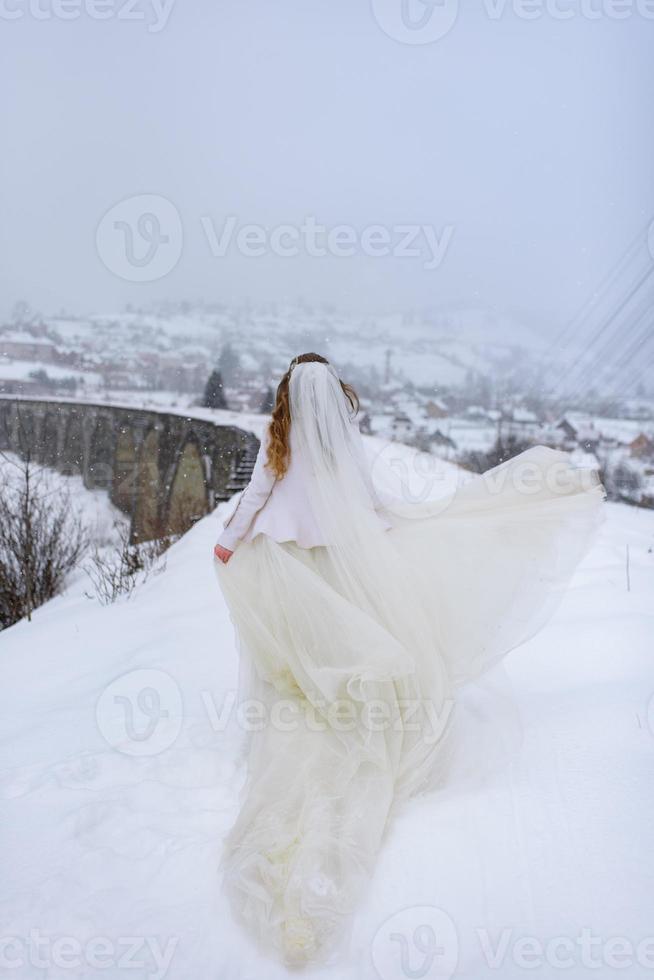 lo sposo conduce la sua sposa per mano a un vecchio faggio solitario. matrimonio invernale. posto per un logo. foto