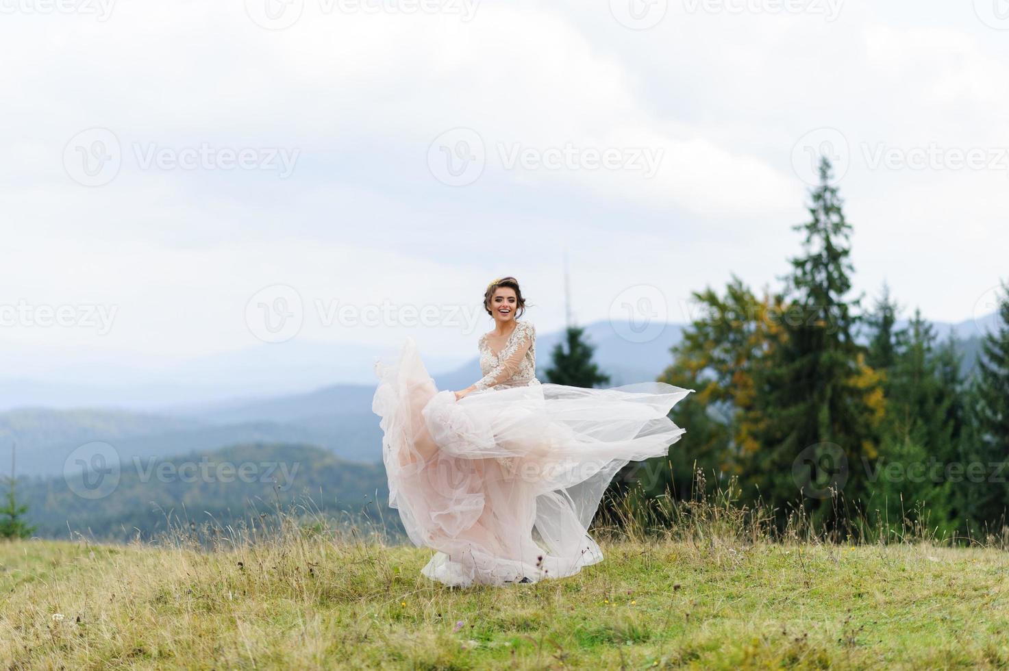 la sposa in un vestito rosa arioso volteggia e gioca con il suo vestito. foto