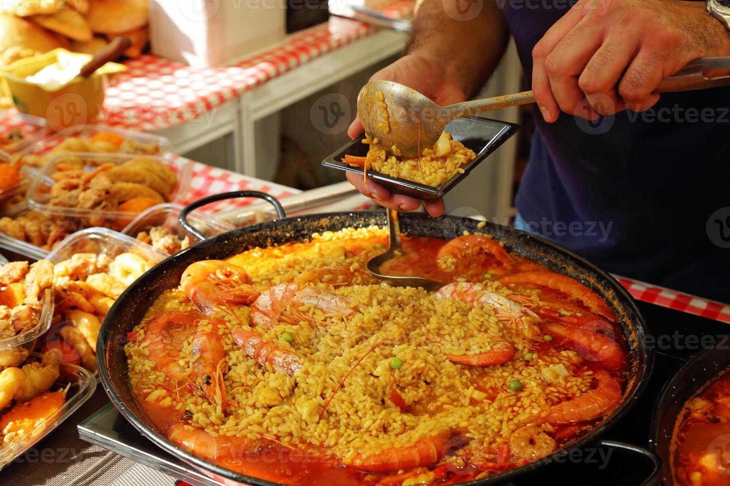 preparazione della paella - bancarella del mercato di strada vicino alla piazza del duomo di barcellona foto