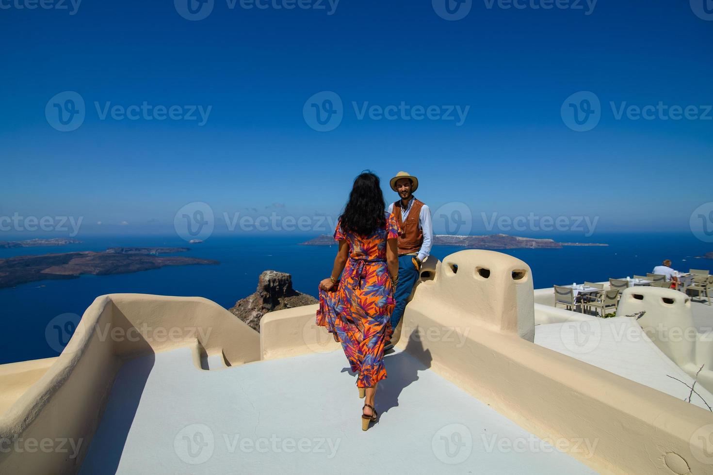 un uomo e una donna si abbracciano sullo sfondo della roccia di skaros sull'isola di santorini. il paese di imerovigli. foto