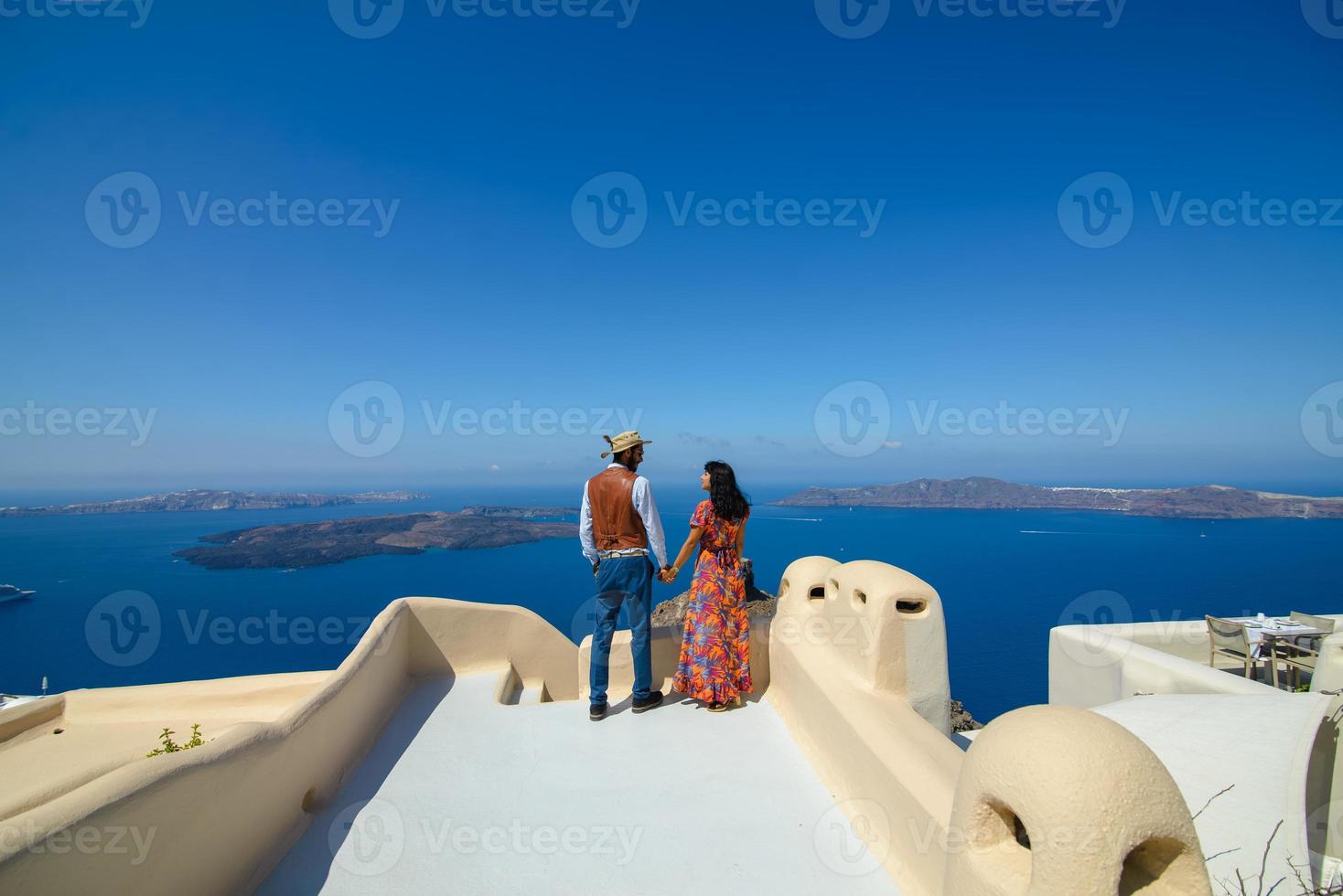 un uomo e una donna si abbracciano sullo sfondo della roccia di skaros sull'isola di santorini. il paese di imerovigli. foto