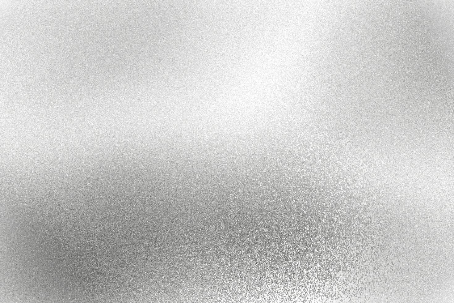 luce che brilla sulla parete metallica antigraffio argento con spazio per la copia, sfondo a trama astratta foto