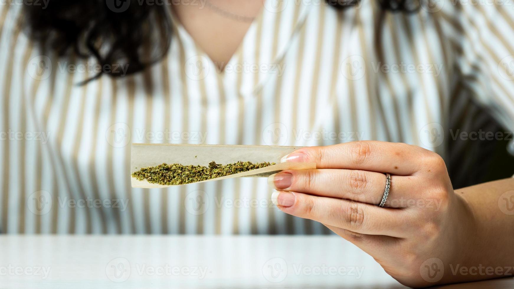 primo piano della mano femminile che tiene giunto di marijuana medica foto
