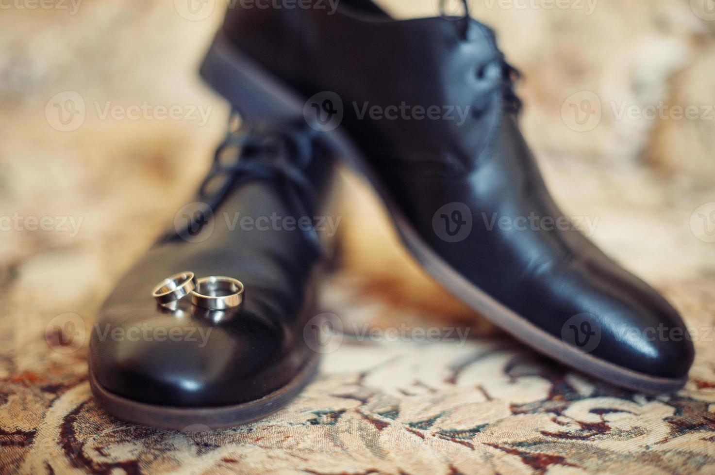scarpe da uomo nere e fedi nuziali foto