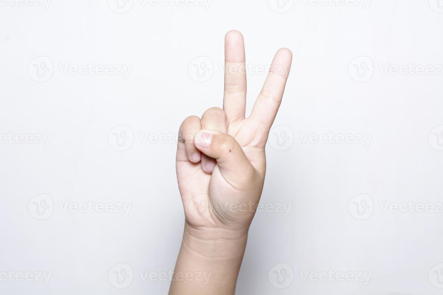 ragazza che alza due dita a portata di mano mostra la lotta della forza della pace o il simbolo della vittoria e la lettera v nella lingua dei segni su sfondo bianco. foto
