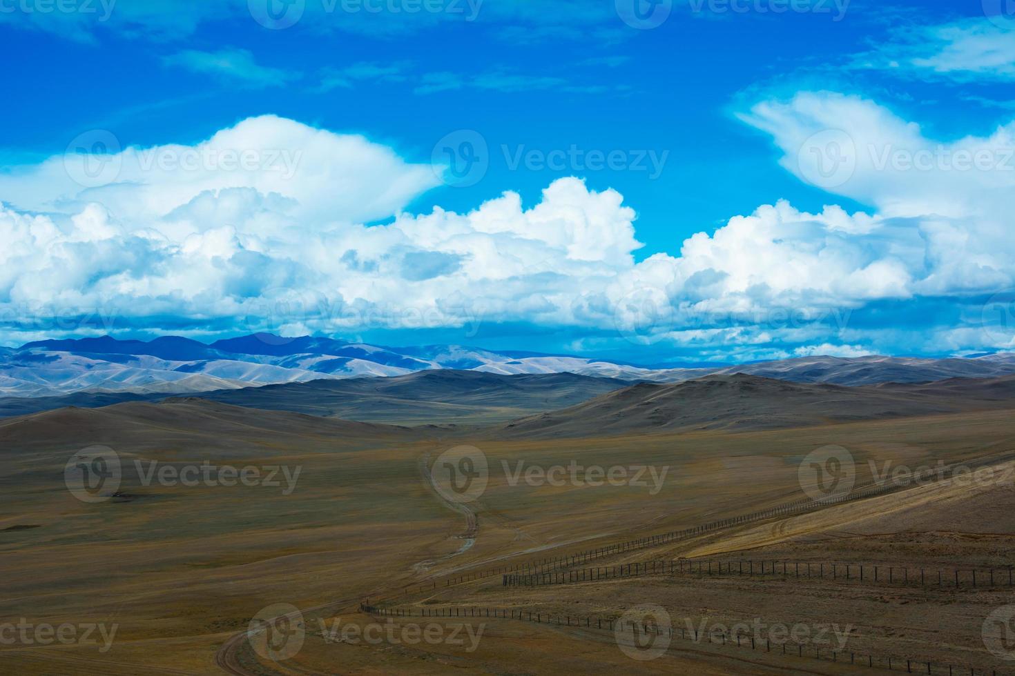 paesaggio della steppa con una strada, montagne, cielo blu foto