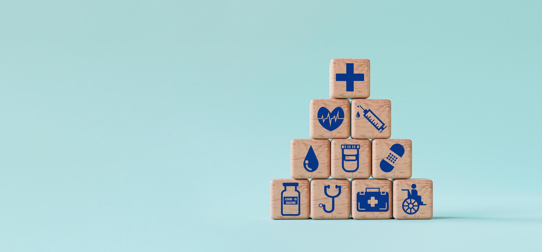 le icone mediche e sanitarie stampano lo schermo su un blocco cubo di legno su sfondo blu e copiano lo spazio mediante rendering 3d. foto