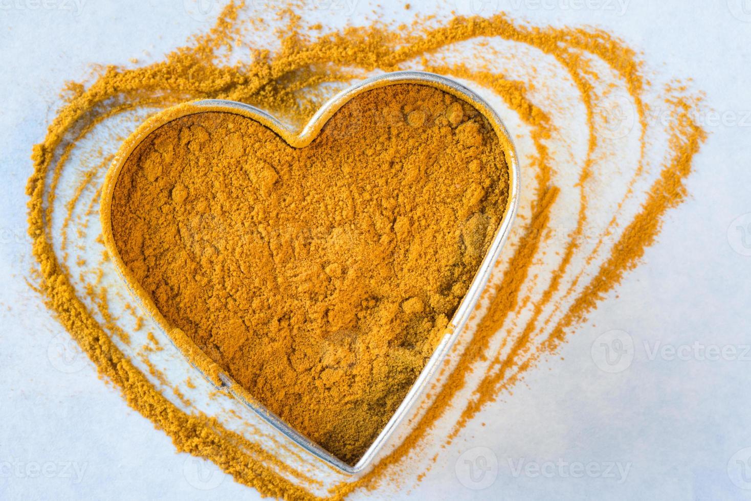 radice di curcuma macinata a forma di cuore foto