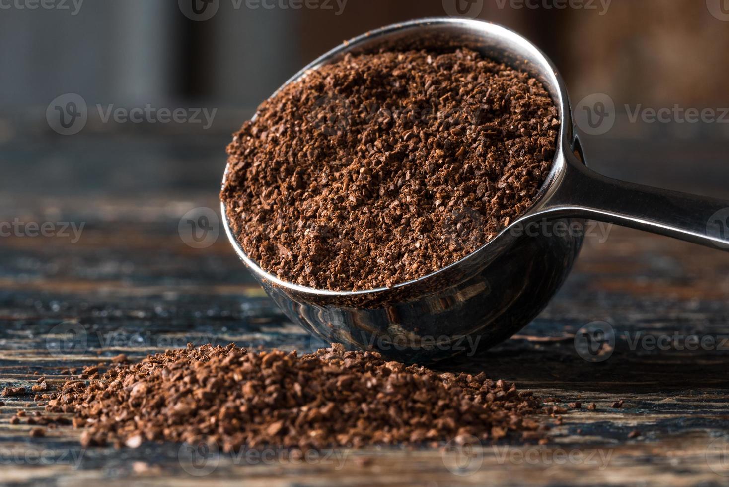 chicchi di caffè macinato rovesciati da un misurino foto