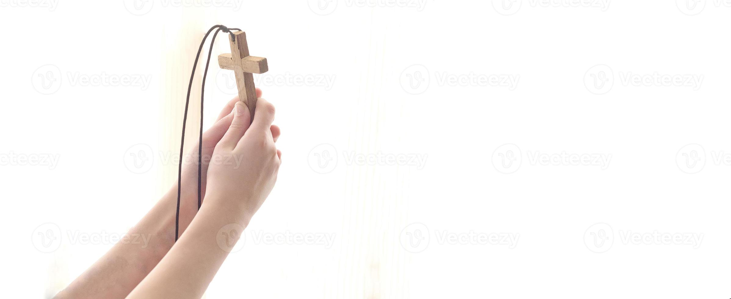 mani tese con una croce a dio nella luce. foto