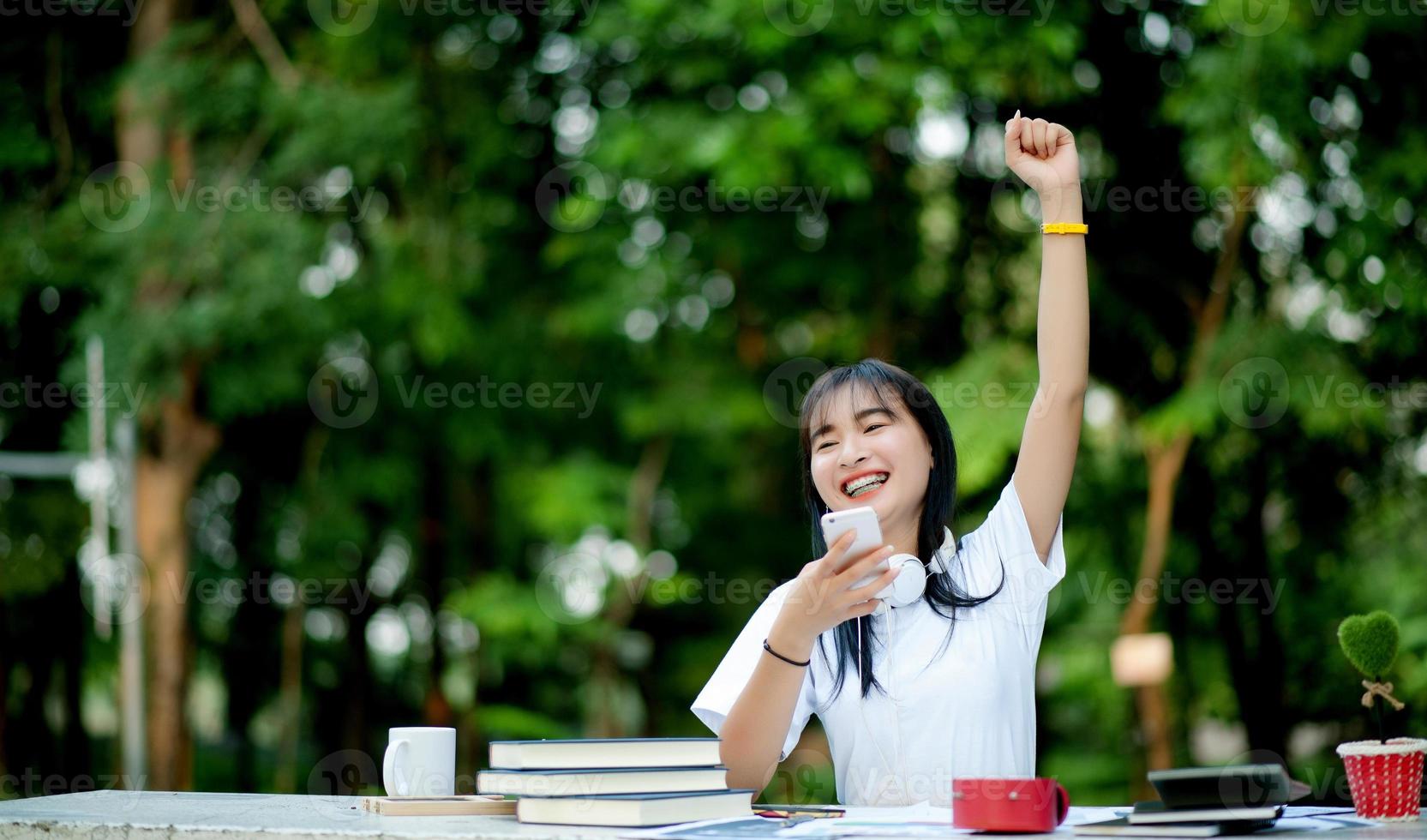 ascoltare la musica. una bella donna con le cuffie si sta rilassando sulla sua scrivania. sorridere e meditare meditazione sta ascoltando musica usando il suo smartphone, concetto di relax e relax. foto