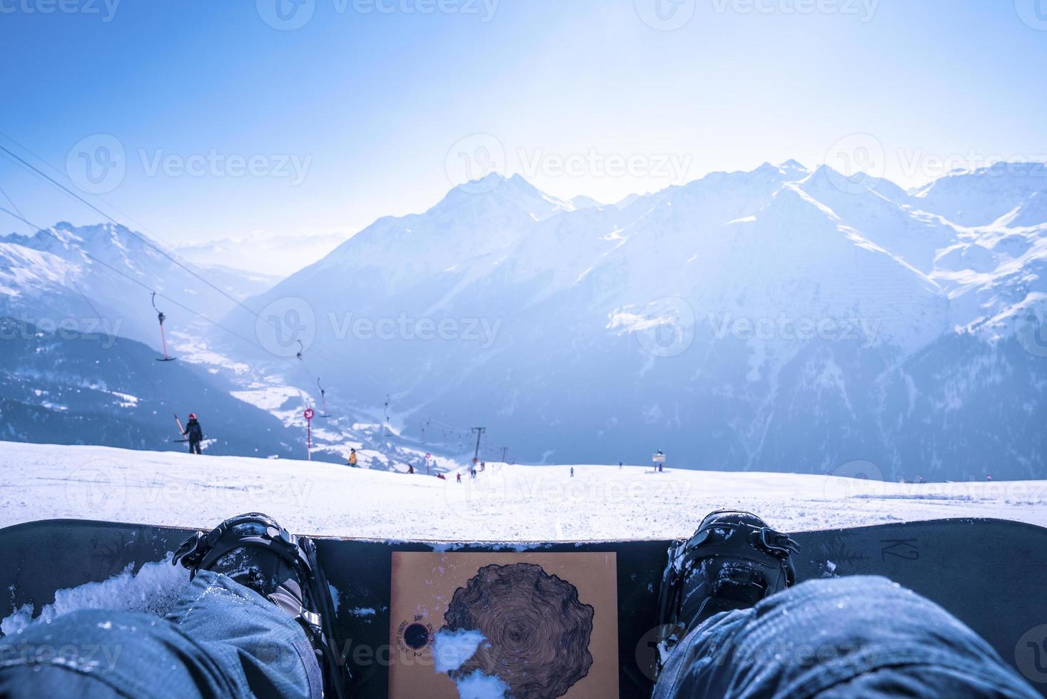 gambe dell'uomo snowboard sul paesaggio montano innevato foto