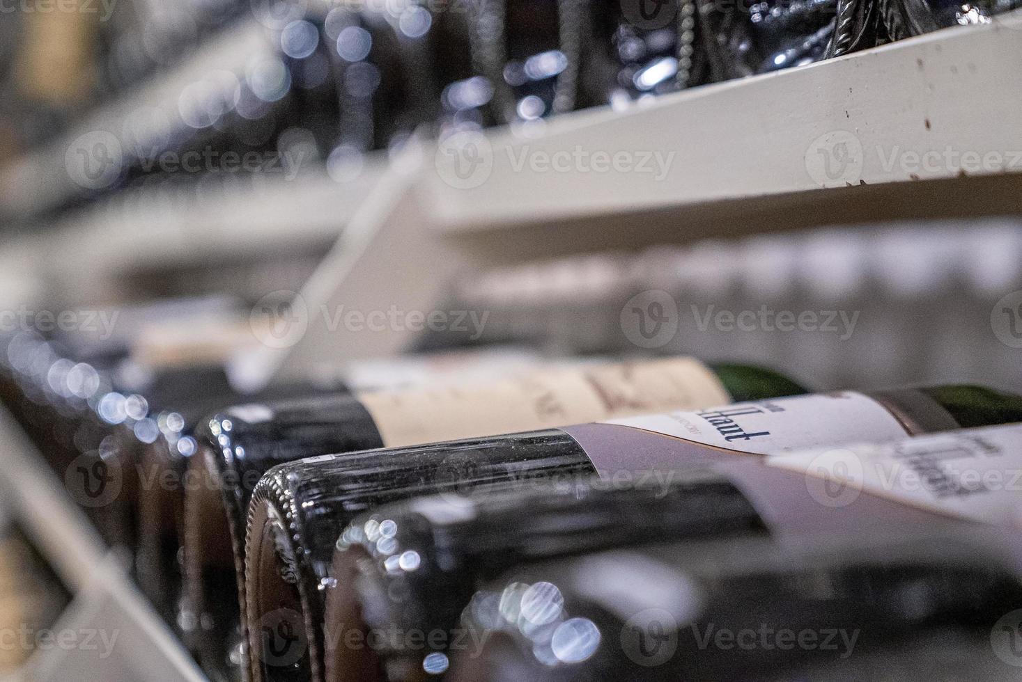 varietà di vino in bottiglie di vetro su scaffali nel supermercato moderno foto