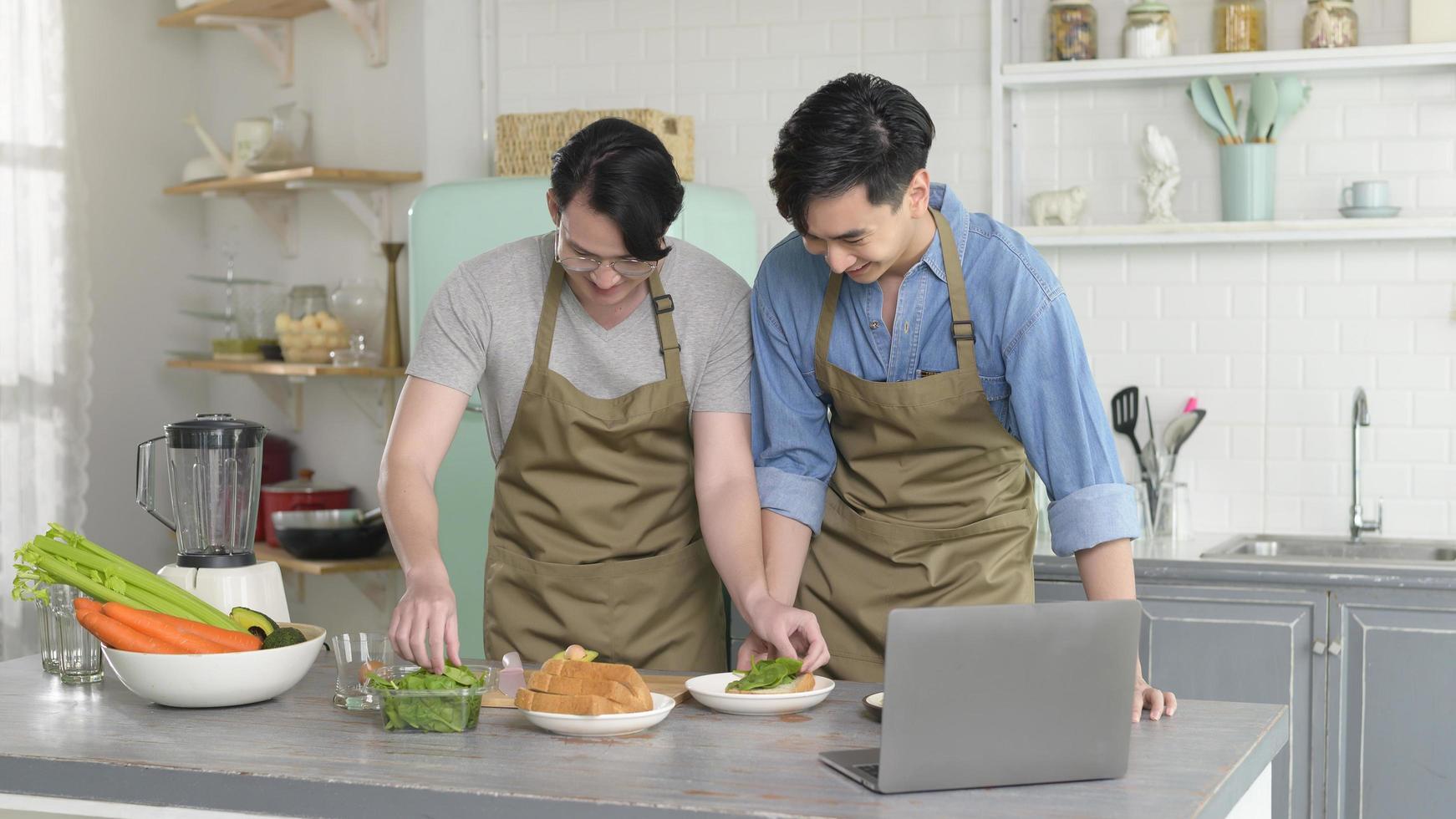 giovane coppia gay sorridente che cucina insieme in cucina a casa, lgbtq e concetto di diversità. foto