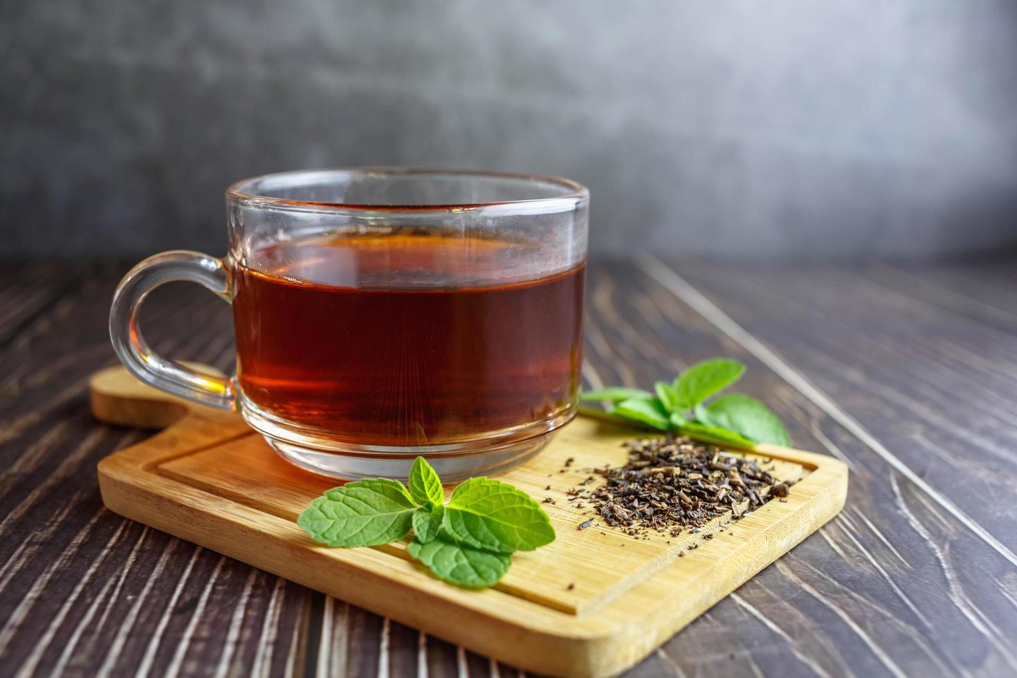 tè in tazza di vetro su fondo di legno foto