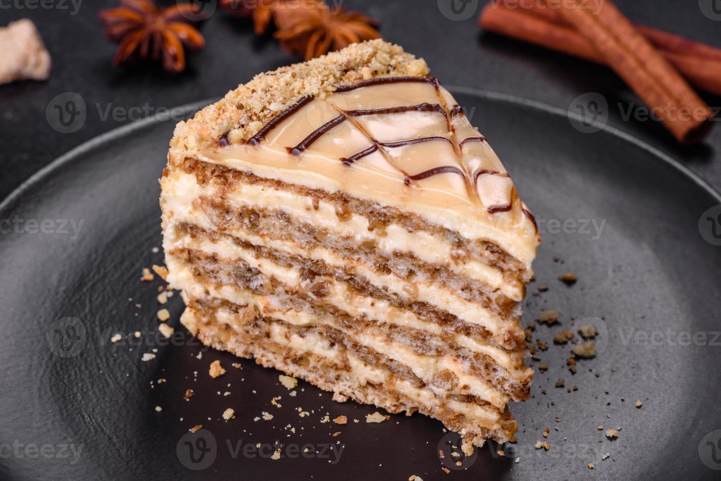 torta esterhazy affettata sul primo piano del piatto nero. dolce di salumeria con pasta di meringa alle mandorle e crema al burro foto