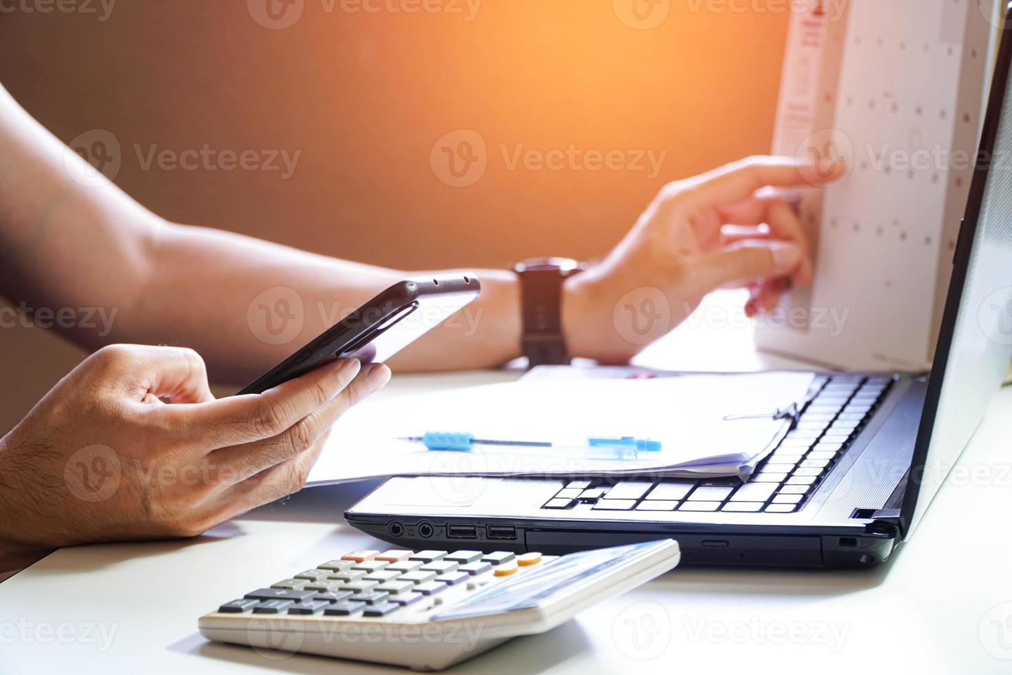 primo piano di un uomo impegnato a pagare le bollette online sul computer che calcola le finanze domestiche o le tasse sulla macchina, la donna gestisce le spese familiari domestiche, utilizzando la calcolatrice, effettua il pagamento sul laptop foto