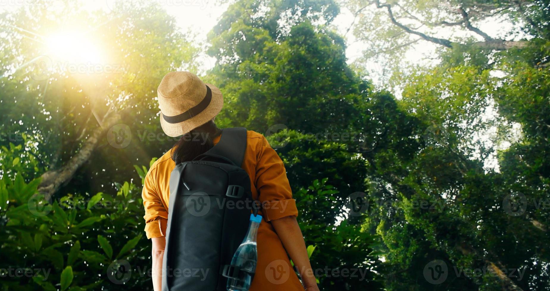 donna in viaggio con zaino godendo di esplorare e fare trekking nella foresta pluviale tropicale dell'asia, viaggiatore turistico su sfondo vista natura ed ecoturismo. foto