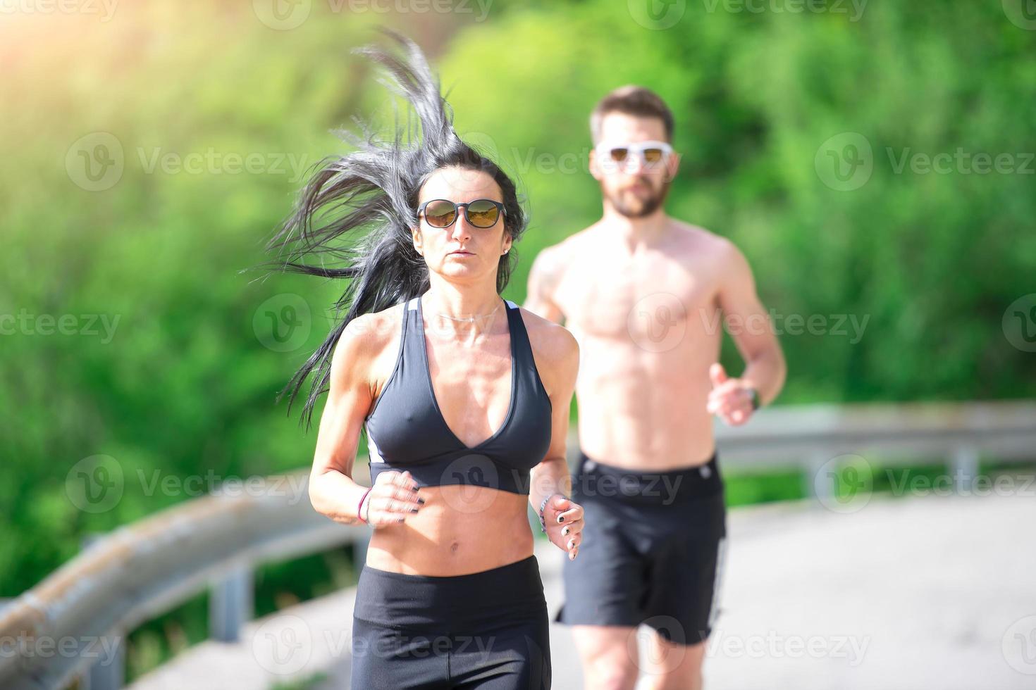 la donna sportiva corre davanti al suo preparatore atletico foto