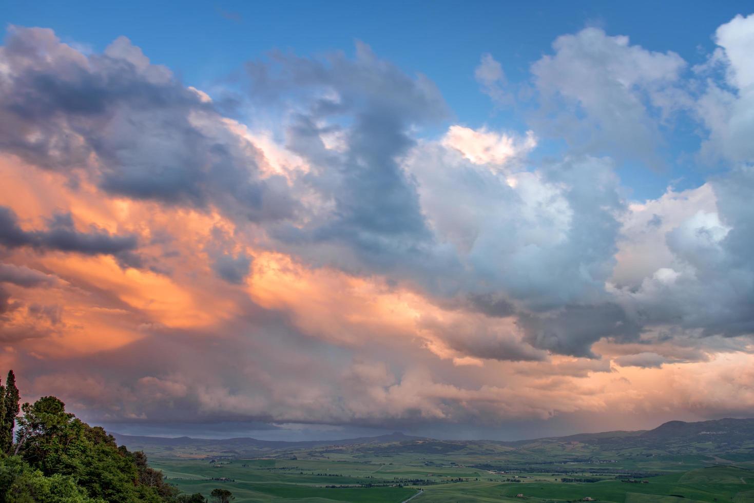 tramonto che illumina le nuvole su terreni agricoli vicino a pienza in toscana foto