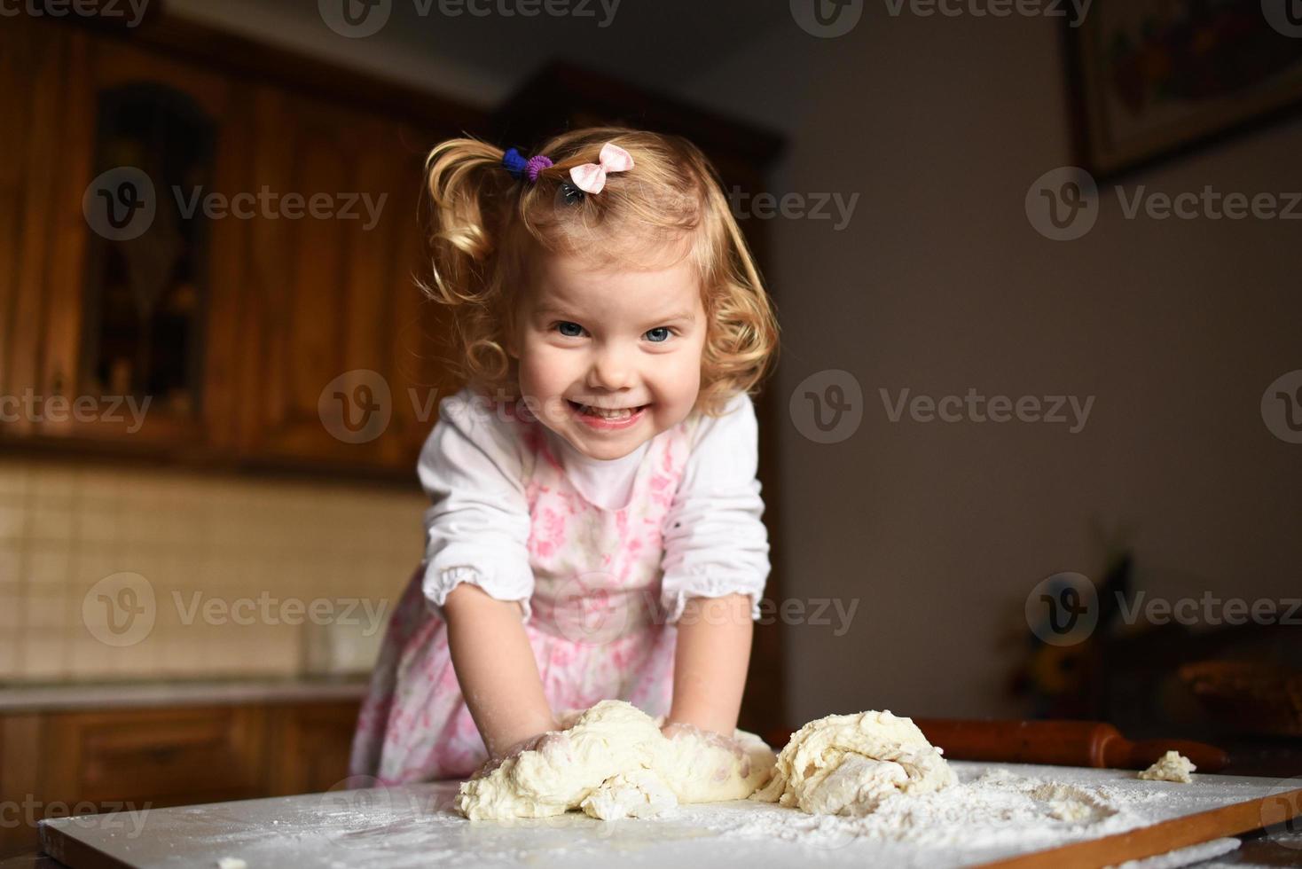 bambina che impasta la pasta foto