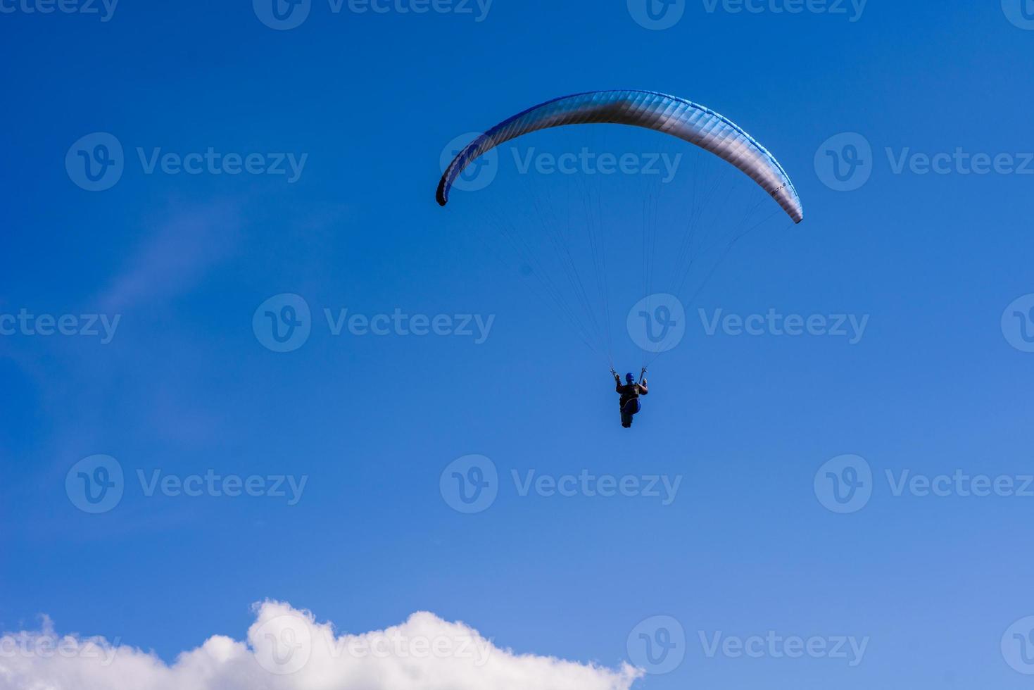 uomo su un paracadute che vola nel cielo limpido foto