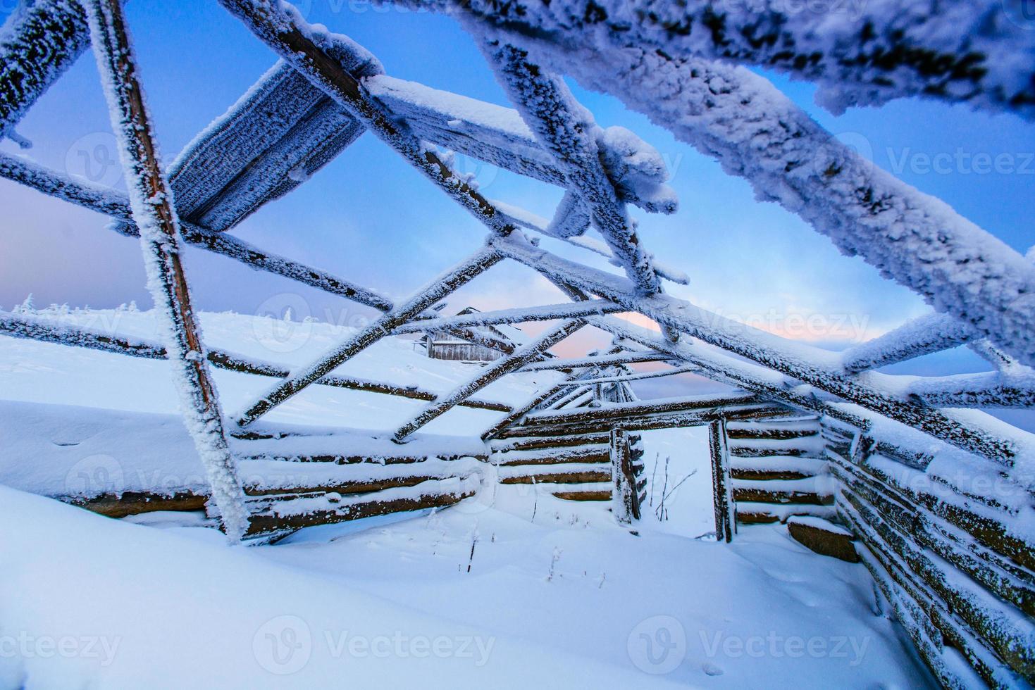 capanna rotta dal mezzo ricoperta di neve foto