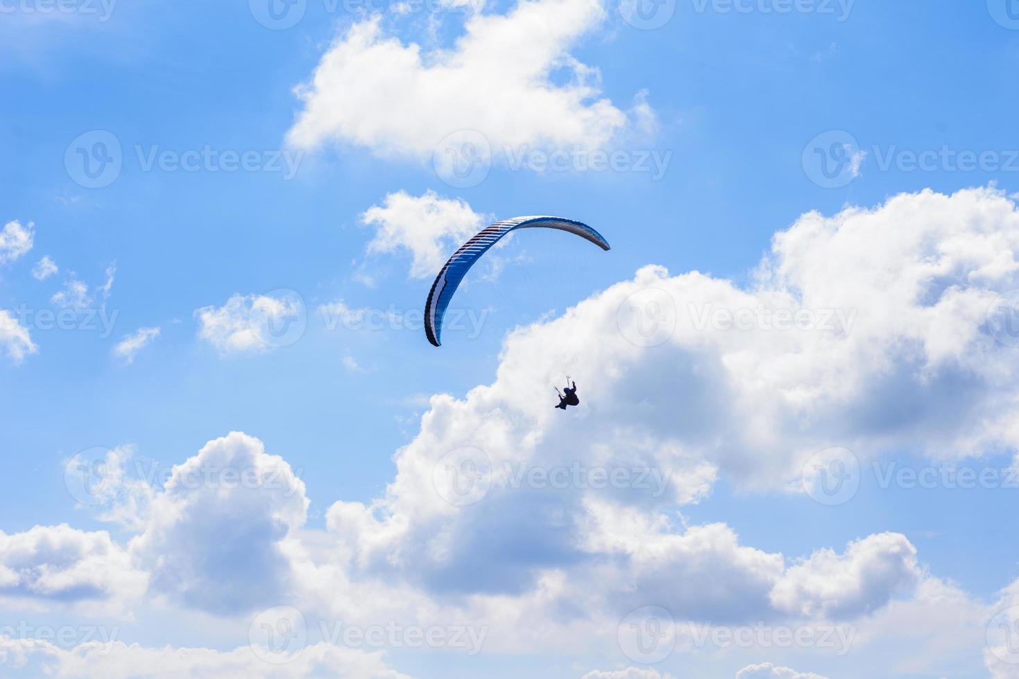 uomo su un paracadute che vola nel cielo limpido foto