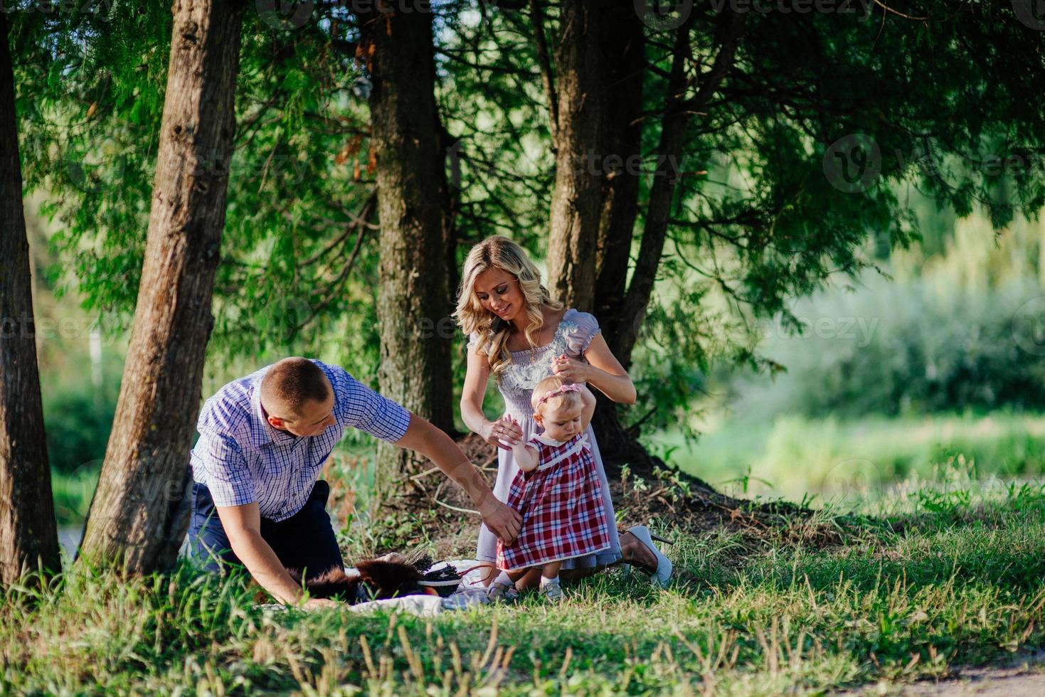 la famiglia felice sta camminando nel verde parco estivo foto