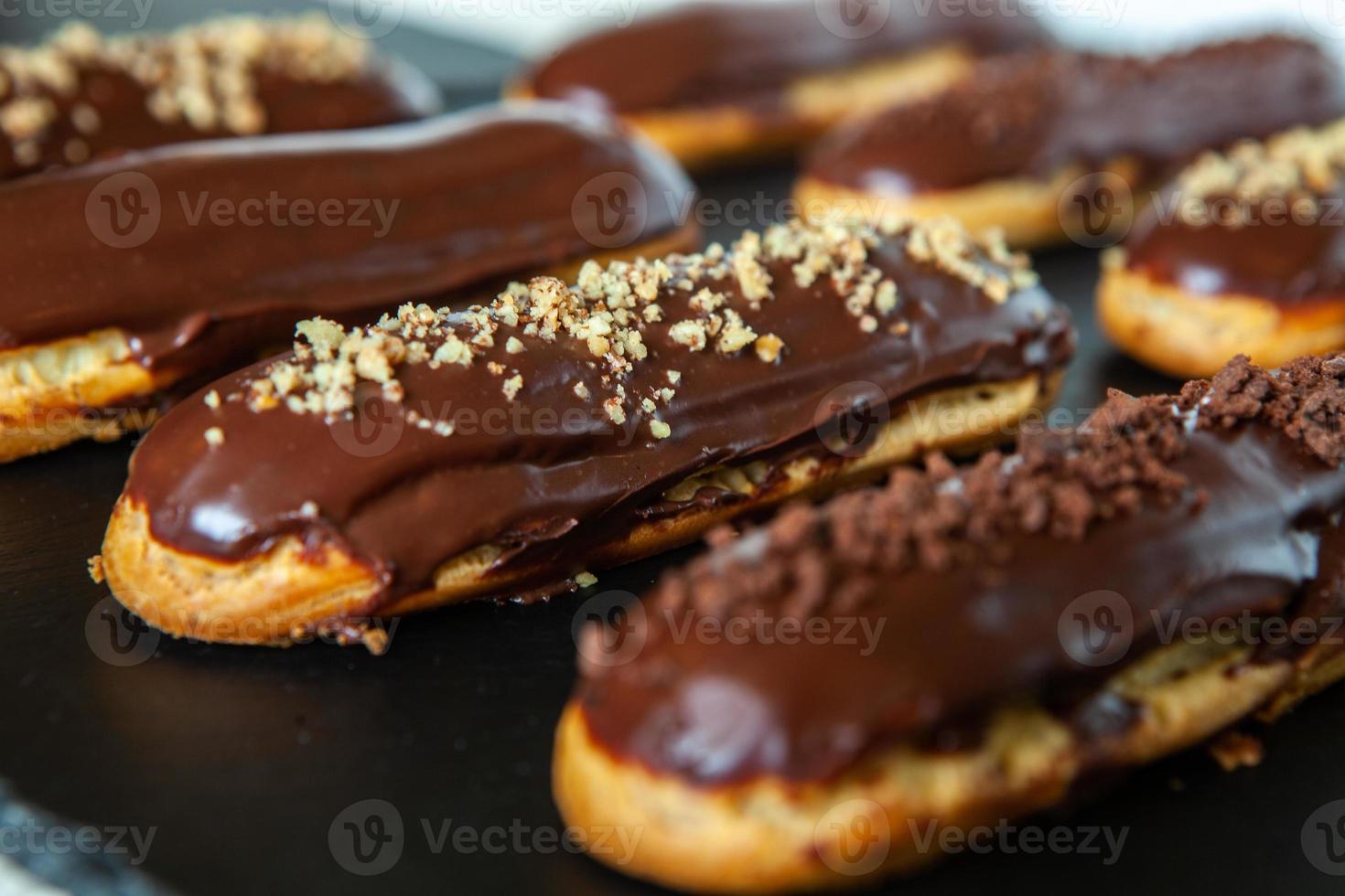 bignè tradizionali francesi al cioccolato. gustoso dessert. bignè fatti in casa. pasticceria dolce ripiena di crema. glassa al cioccolato. foto