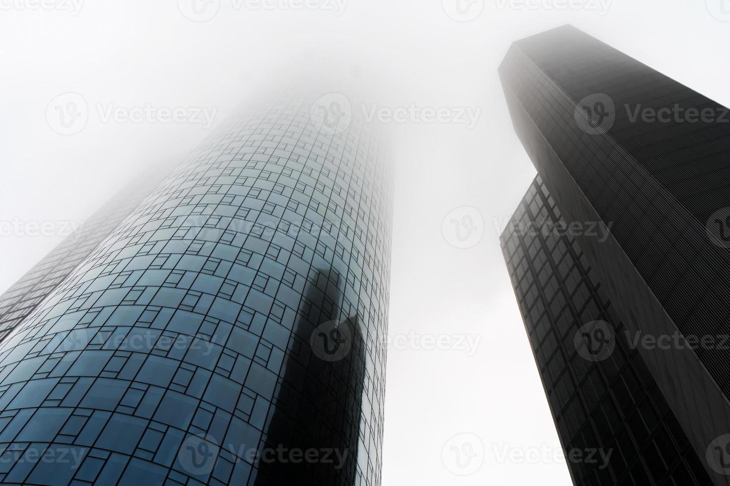 vista ad angolo basso di due grattacieli avvolti nella nebbia o nella foschia nel distretto bancario di francoforte, germania foto