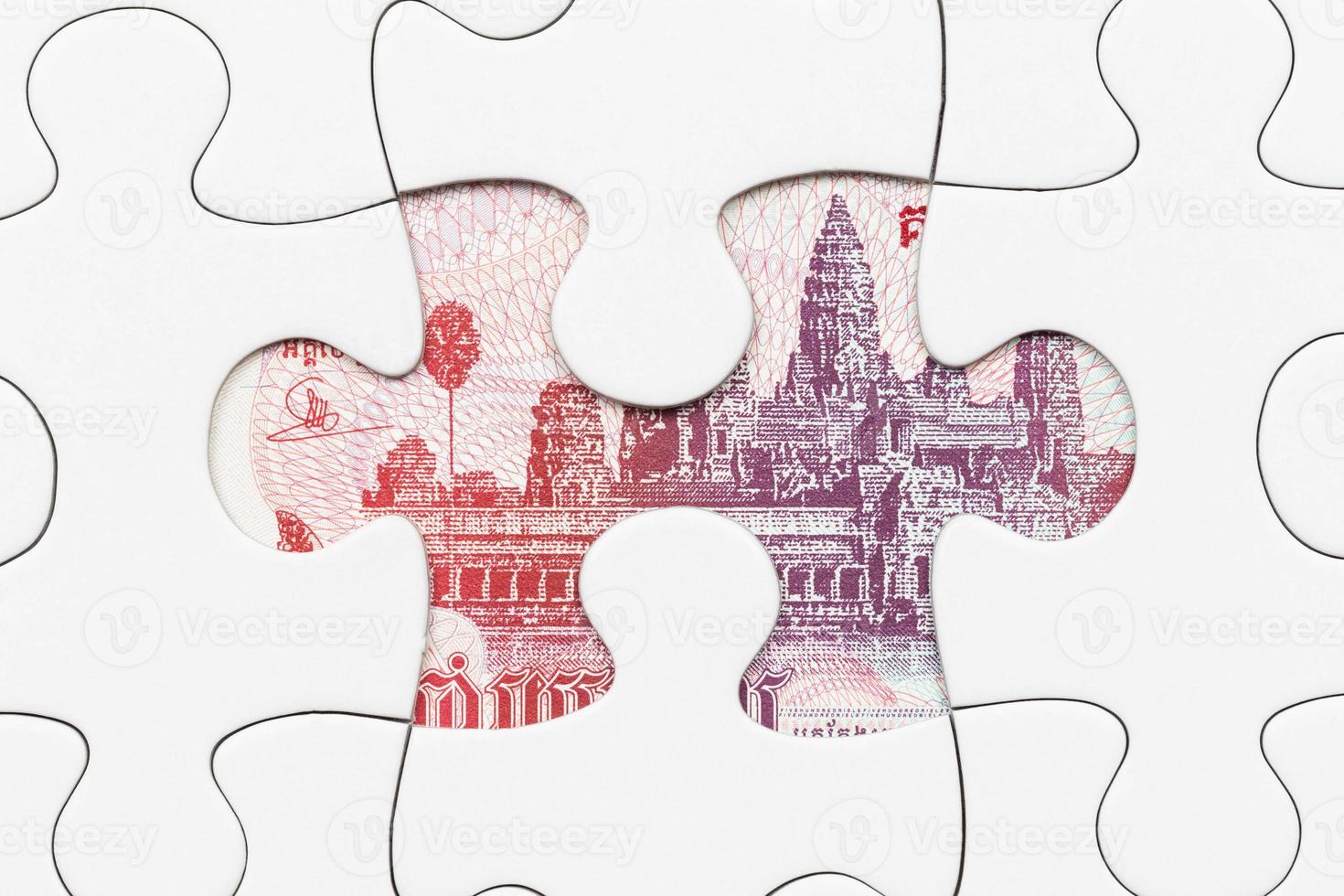 banconota riel cambogiana nascosta sotto il concetto finanziario di puzzle foto