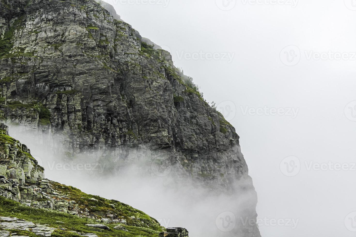 nebbia, nuvole, rocce e scogliere sulla montagna veslehodn veslehorn, norvegia. foto