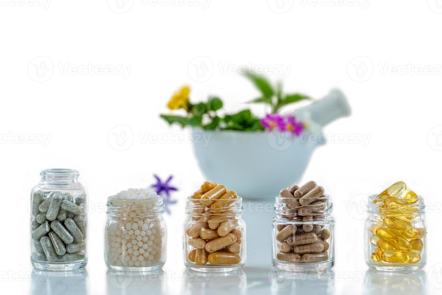 bottiglia di pillole integratori alimentari medicina sana, farmaci trattamento sanitario additivi farmacia con mortaio in ceramica bianca con piante medicinali fresche sullo sfondo foto