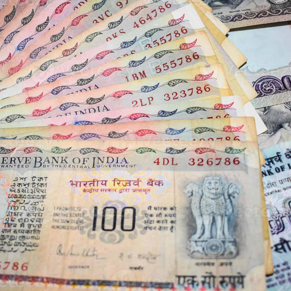 vecchie banconote da cento rupie combinate sul tavolo, denaro indiano sul tavolo rotante. vecchie banconote in valuta indiana su una tavola rotante, valuta indiana sul tavolo foto